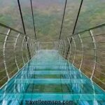 Glass Bridge Rajgir Bihar with tourists walking on transparent glass deck surrounded by lush hills.